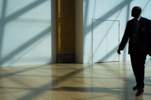 Security guard walking in a suit and tie within a professional business office