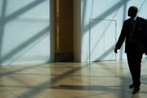 Security guard dressed in a suit walking through building lobby